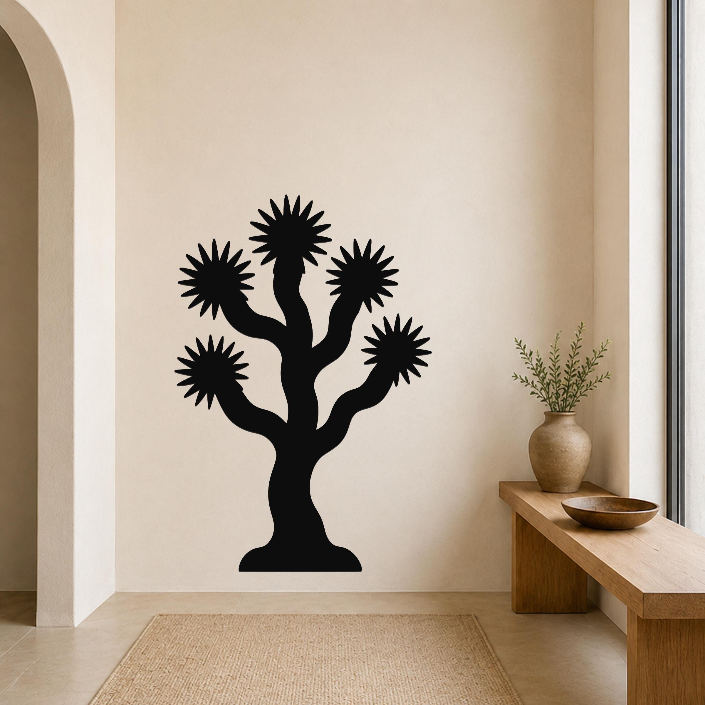 Black metal wall art silhouette of a Joshua tree with starburst-shaped branches, mounted on a beige wall above a wooden bench in a minimalist entryway.