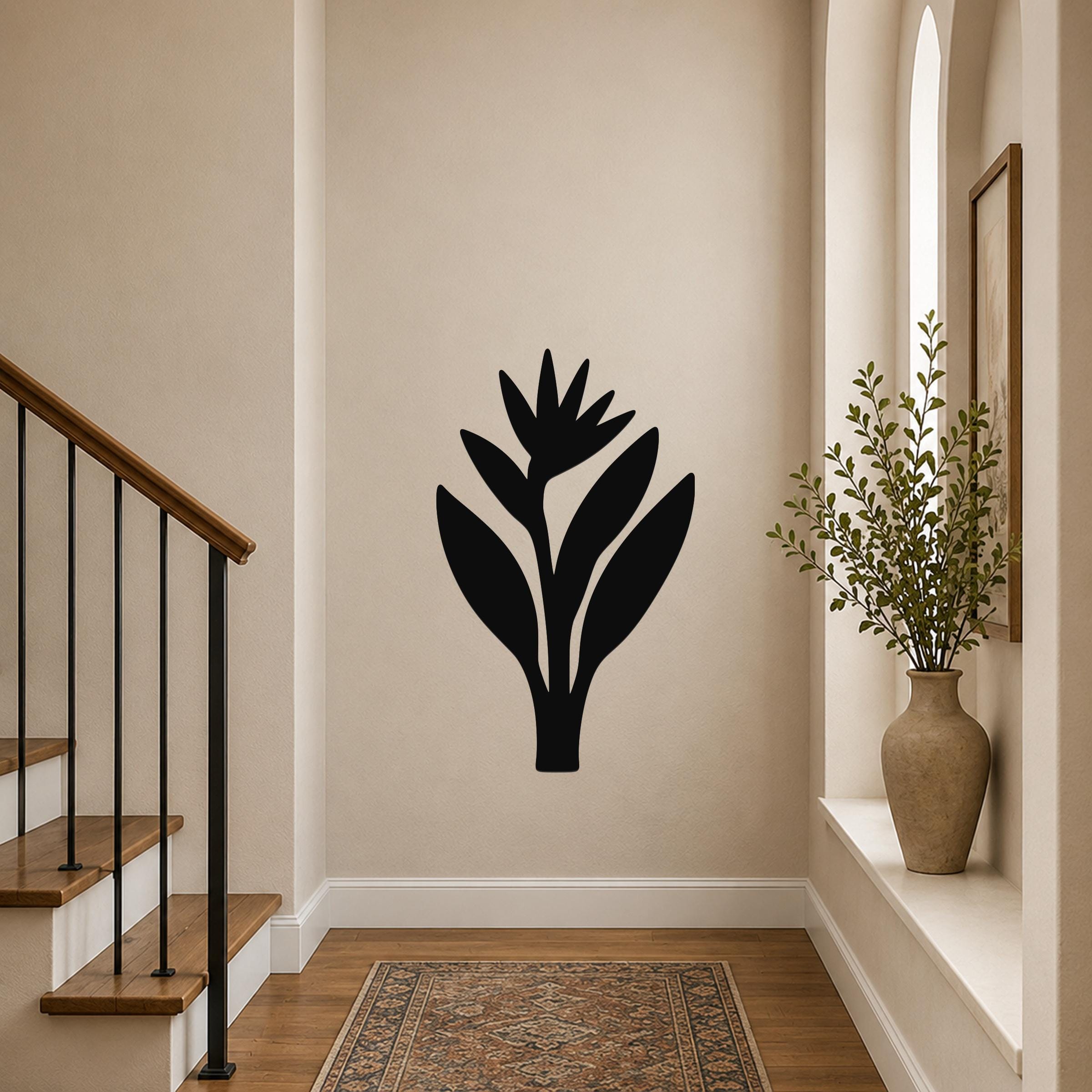 Black metal wall art in a Bird of Paradise silhouette, mounted on a hallway wall above a patterned rug near a staircase.