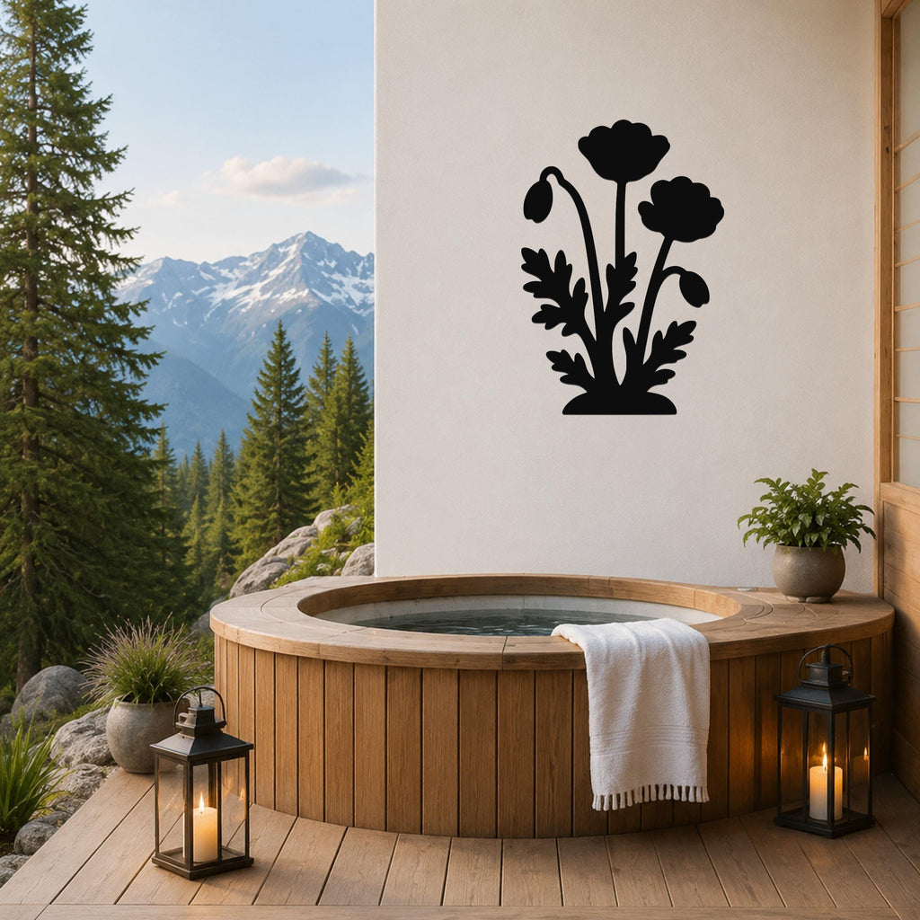 Black metal poppy wall art with three flower silhouettes and leaf cutouts, mounted on a white wall above a wooden hot tub on a mountain-view deck.