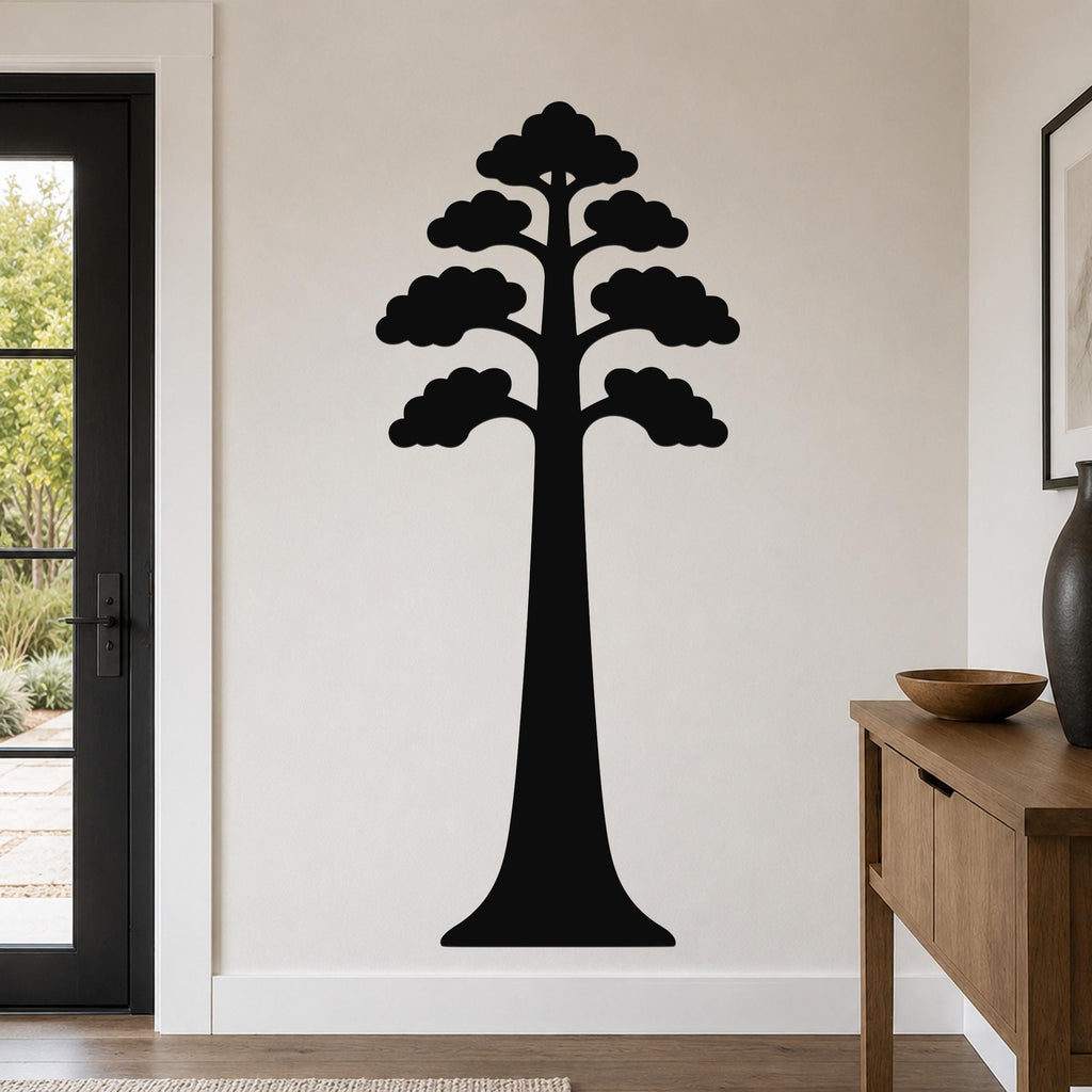 Black metal sequoia tree wall art with layered canopy cutouts, mounted on a living room wall above a wooden console table.