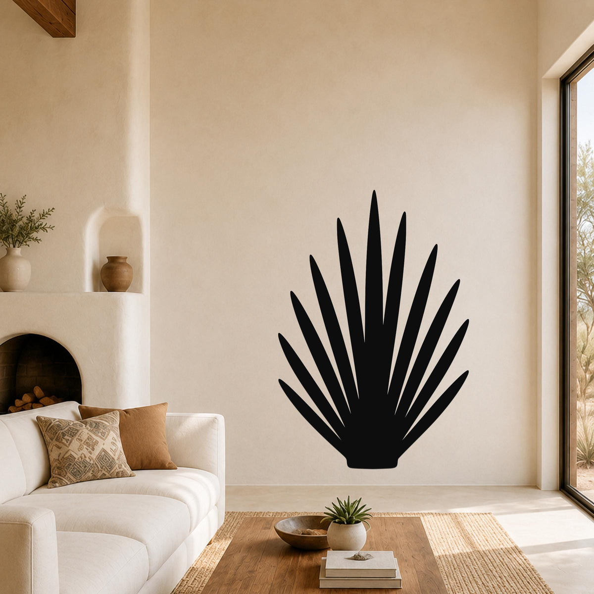 Black metal wall art in a fan-shaped agave silhouette, mounted on a living room wall above a white sofa.