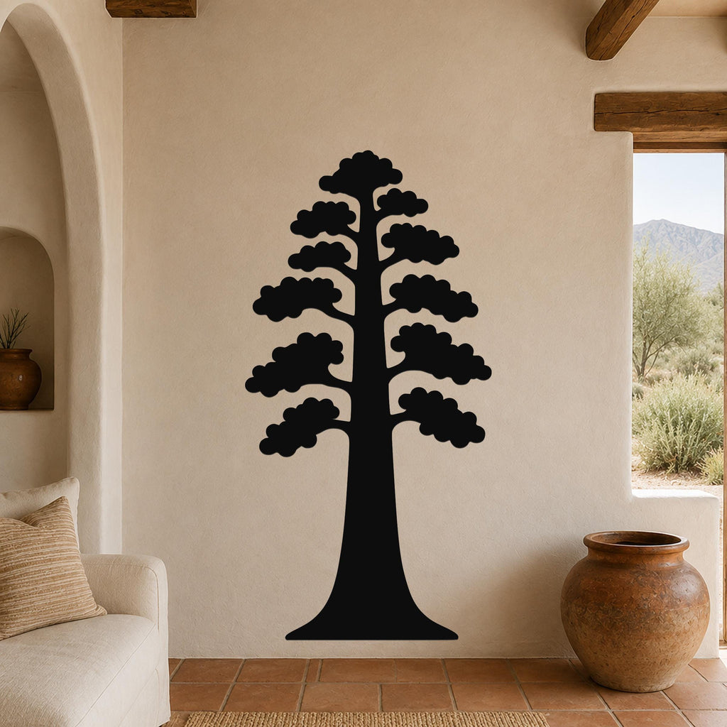 Black metal wall art of a sequoia tree silhouette with layered branches, mounted on a beige living room wall above a sofa.