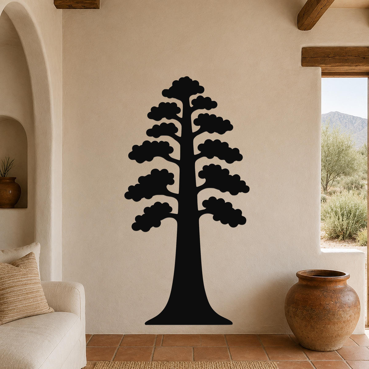 Black metal wall art of a sequoia tree silhouette with layered branches, mounted on a beige living room wall above a sofa.