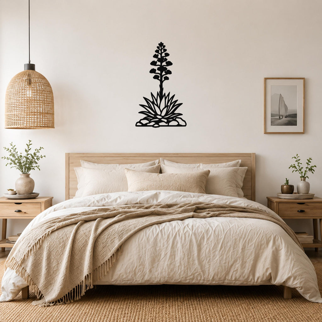 Black metal agave wall art with a blooming flower silhouette, mounted above a bed in a neutral bedroom.