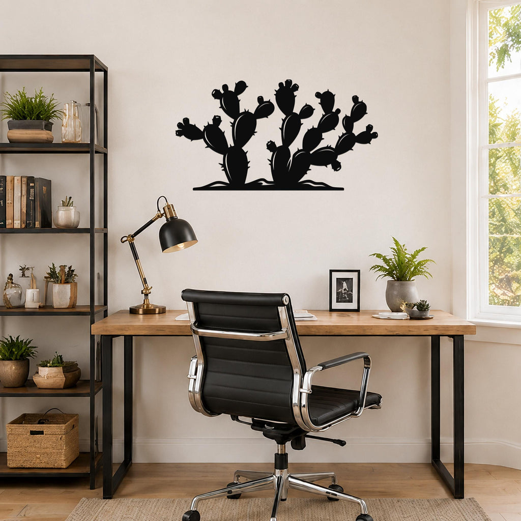 Black metal wall art in a silhouette of a prickly pear cactus, mounted on a wall above a wooden desk in a home office.