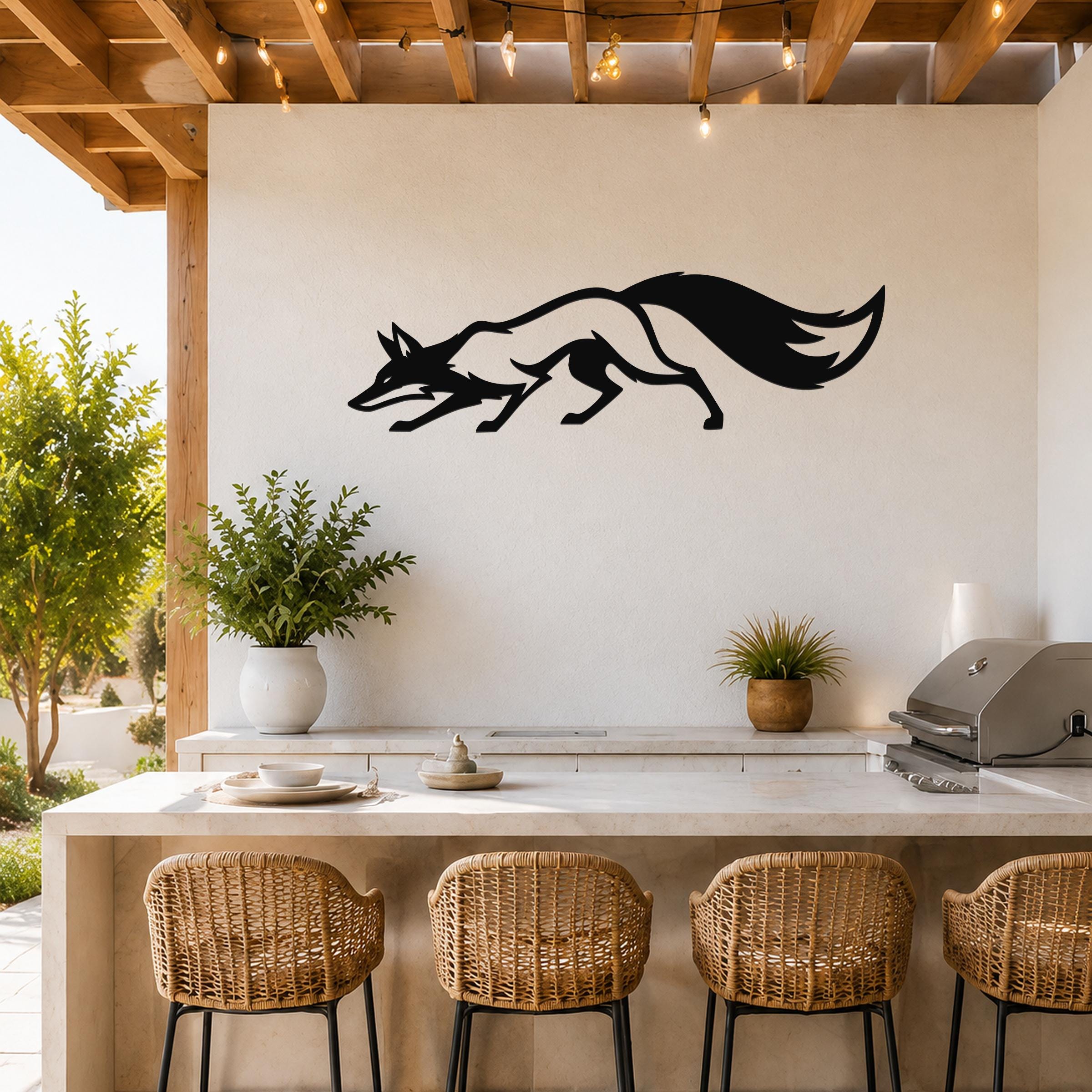 Black metal fox silhouette wall art with motion-line cutouts, mounted above a kitchen counter on a light-colored outdoor patio wall.