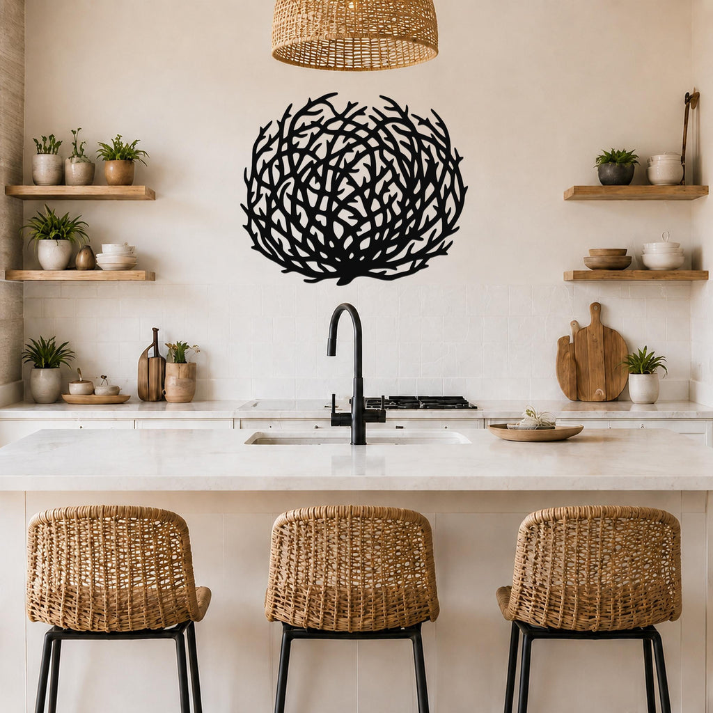 Black metal coral wall art with intricate branch cutouts, mounted above a kitchen counter in a bright, modern kitchen.