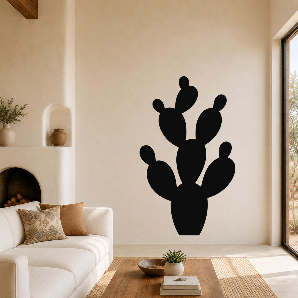 Black metal prickly pear cactus wall art with cutout segments, mounted on a living room wall above a sofa.