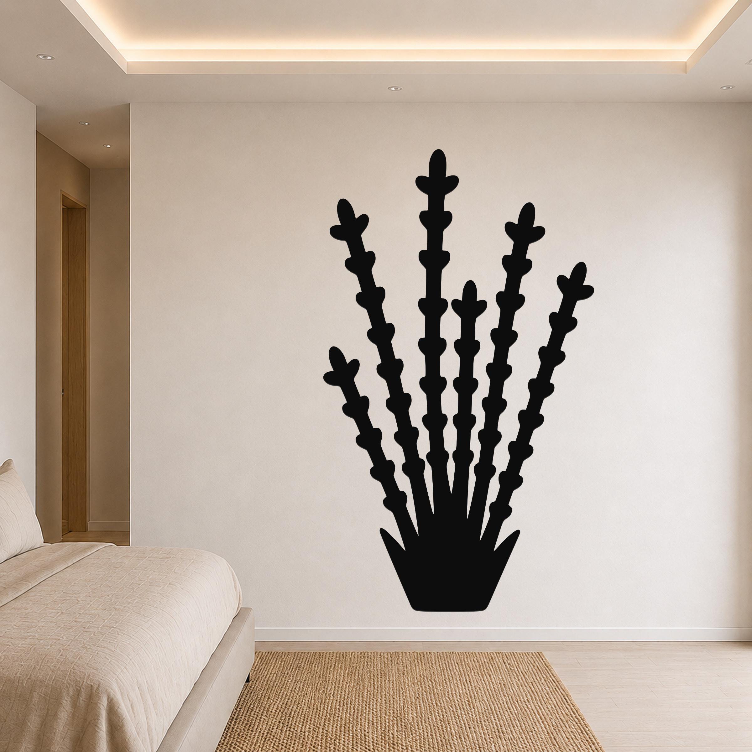 Black metal ocotillo wall art with branching stem cutouts, mounted on a bedroom wall above a bed.