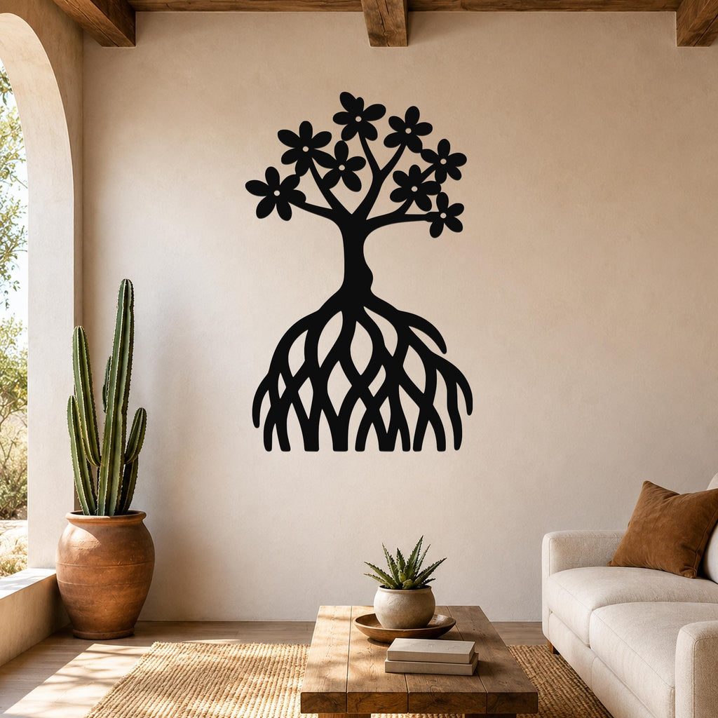 Black metal wall art in the shape of a tree with flowers and exposed roots, mounted on a living room wall above a wooden coffee table.