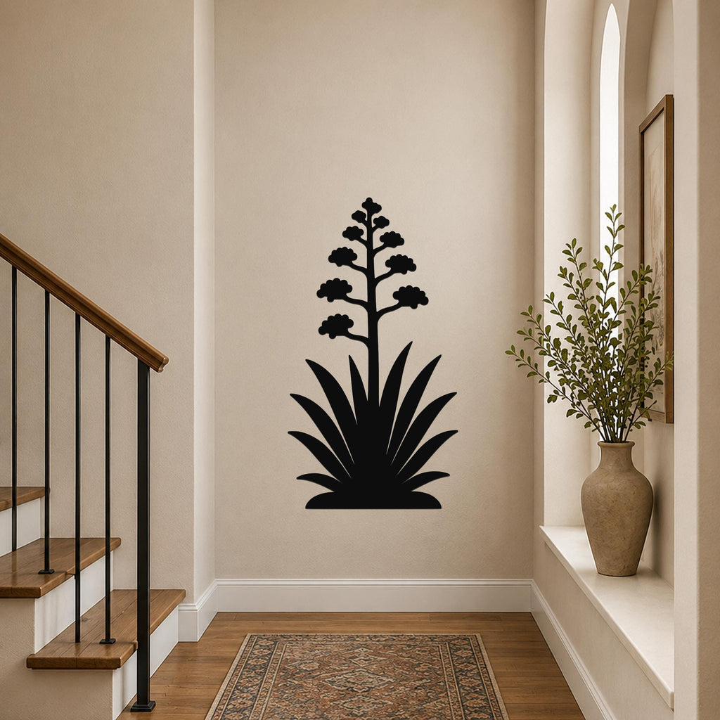 Black metal agave wall art with a blooming flower silhouette, mounted on a hallway wall above a patterned rug.