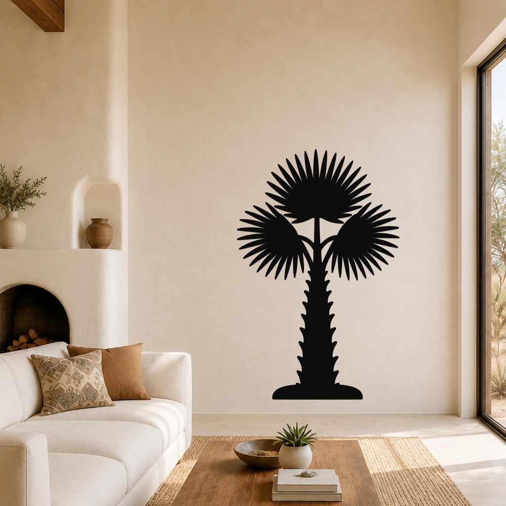 Black metal palm tree wall art with fan-shaped fronds and a textured trunk, mounted on a living room wall above a coffee table.