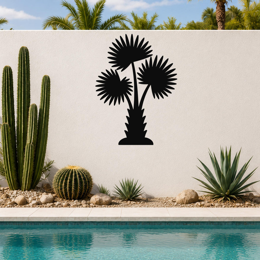 Black metal wall art cutout of a fan palm tree with three fronds, mounted on a white outdoor wall above a pool and desert plants.