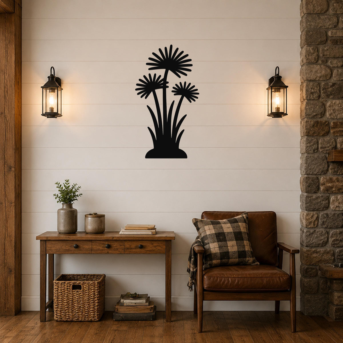 Black metal wall art featuring a silhouette of three wildflowers with long stems and leafy bases, mounted on a shiplap wall above a wooden console table in a living room.