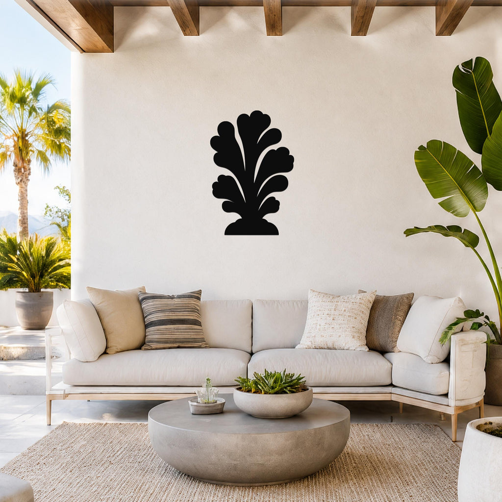 Black metal wall art in a coral silhouette design, mounted on a white wall above a light-colored sofa in a bright living room.