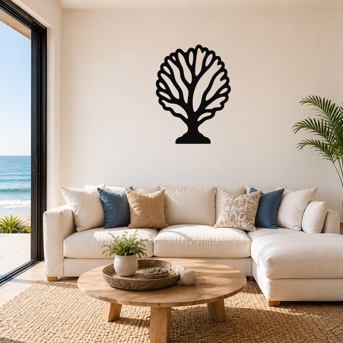 Black metal fan coral wall art with intricate branching cutouts, mounted on a living room wall above a white sofa.