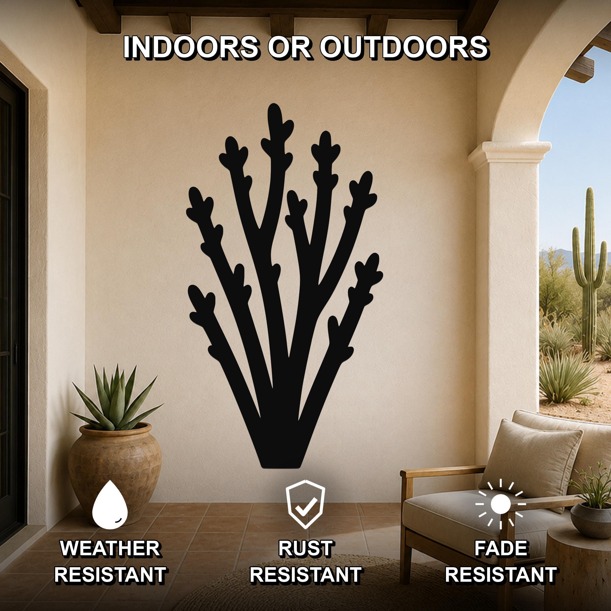 Black metal desert branch wall art with branching cutouts, mounted on a patio wall above a chair and potted plant, suitable for indoor or outdoor use.