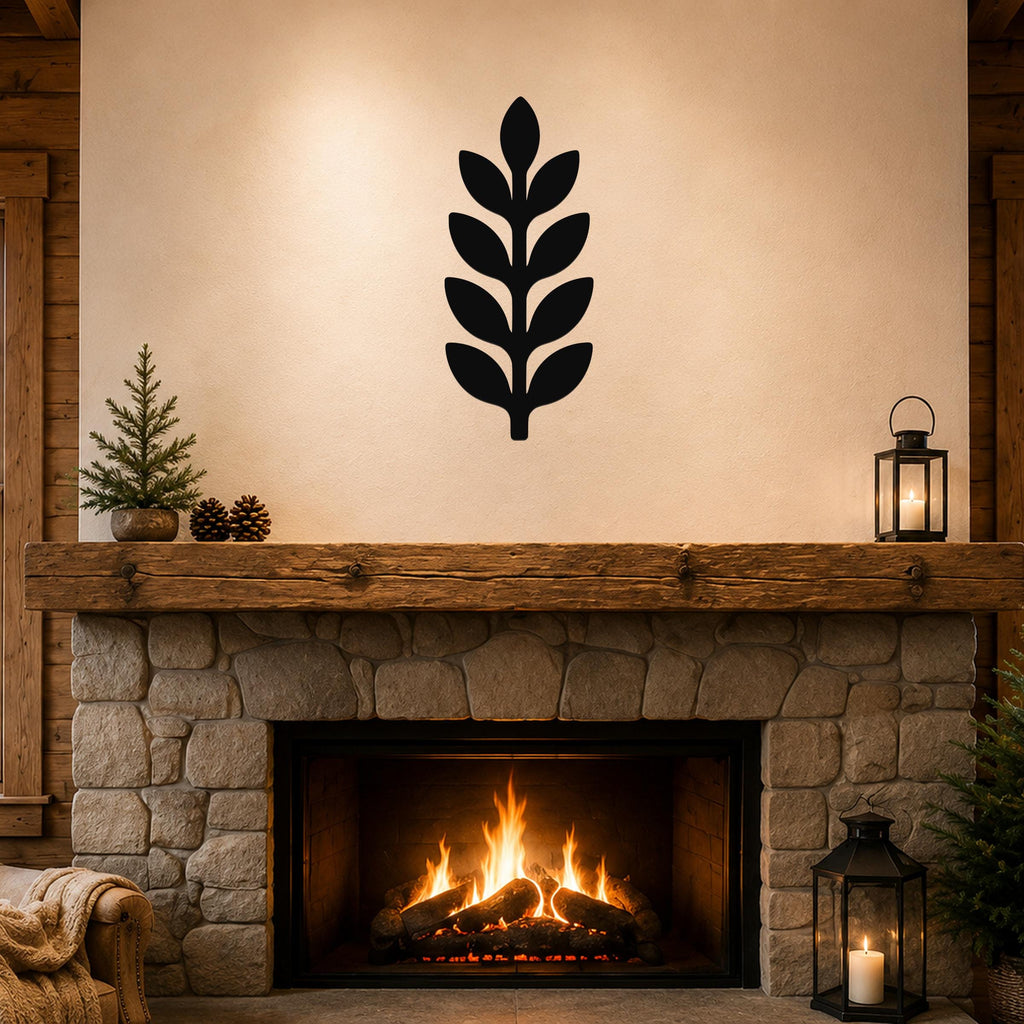 Black metal wall art in a leafy sprig silhouette, mounted above a stone fireplace in a rustic living room.