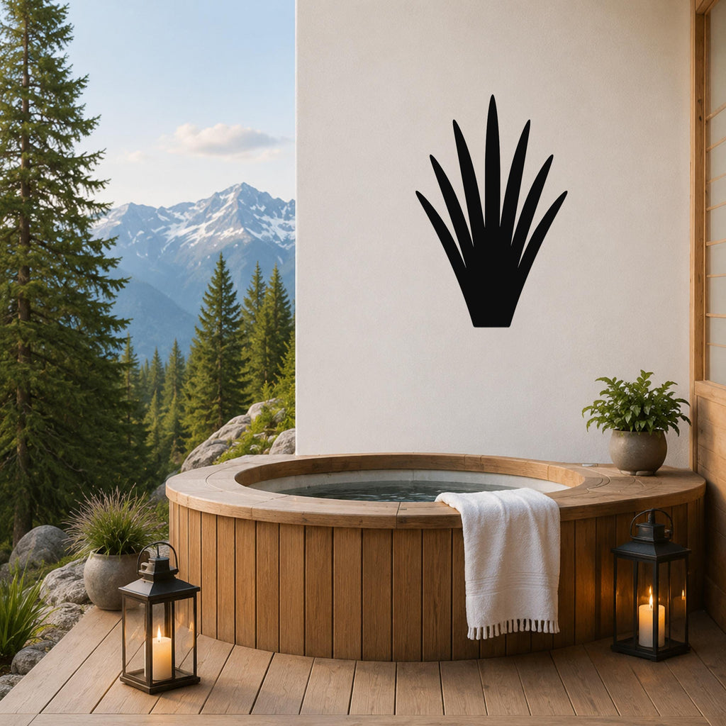 Black metal yucca wall art silhouette mounted on a white wall above a wooden hot tub on a mountain-view patio.