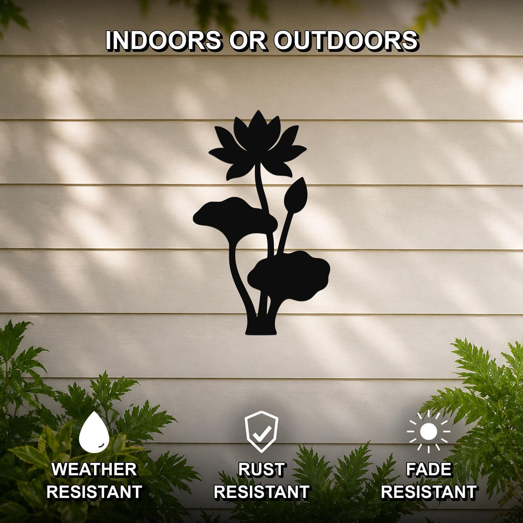 Black metal lotus water lily wall art with flower and leaf cutouts, mounted on a beige outdoor wall with greenery below.