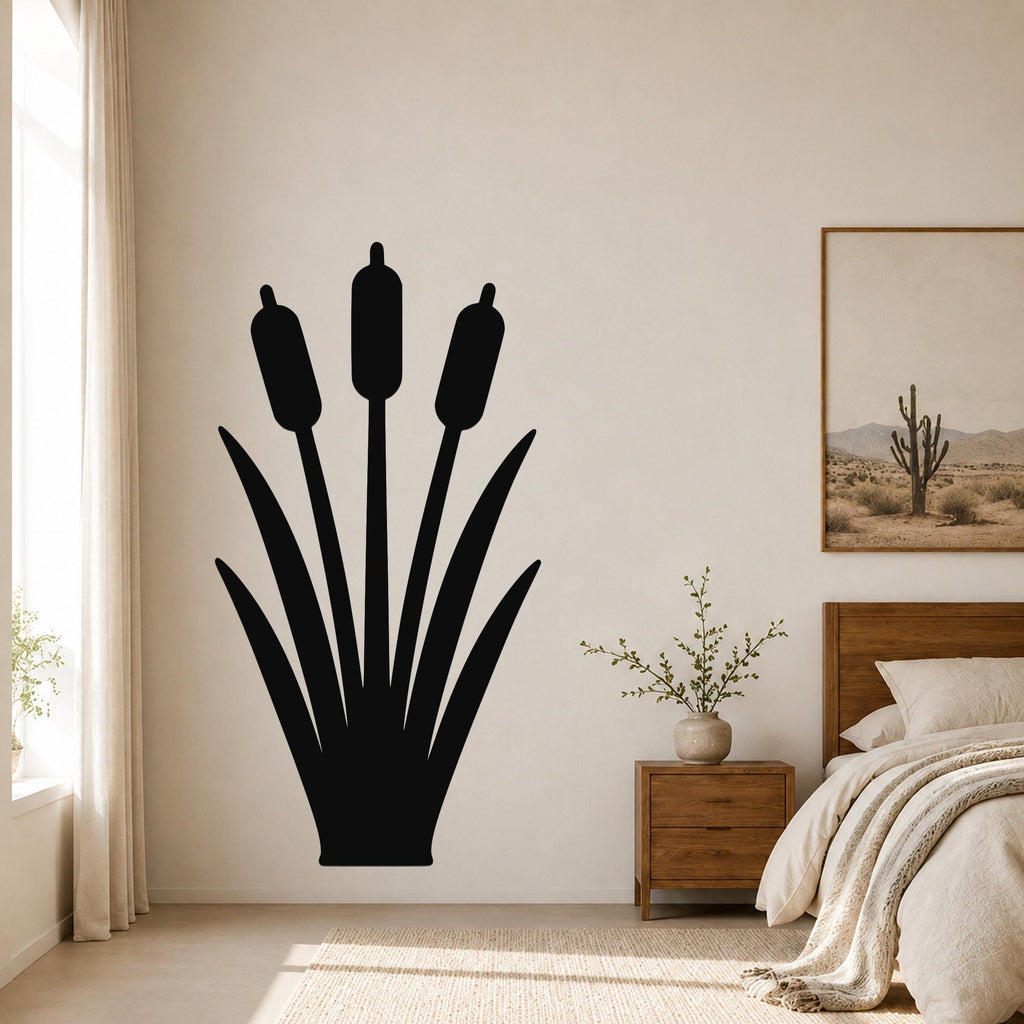 Black metal cattail wall art silhouette with three seed heads and long leaves, mounted on a bedroom wall above a wooden nightstand.