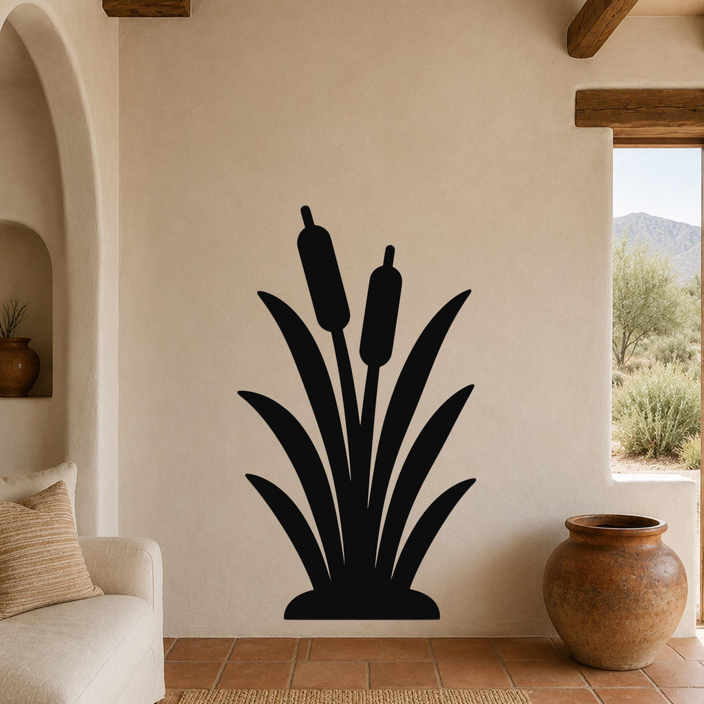 Black metal cattail wall art silhouette with two seed heads, mounted on a beige wall above a sofa in a living room.