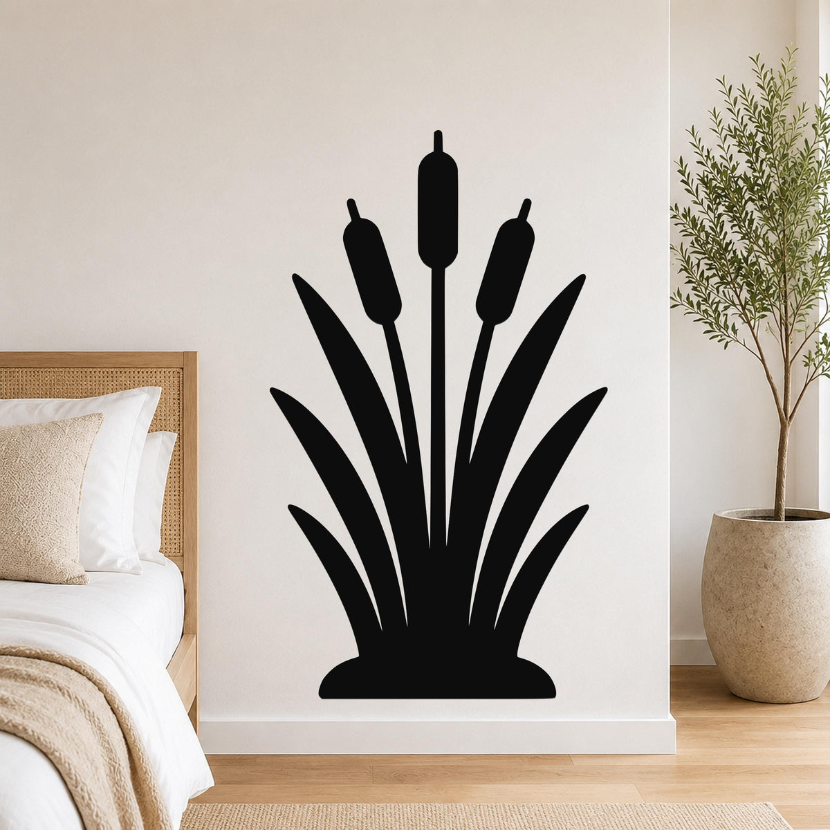 Black metal cattail wall art silhouette with three seed heads and long leaves, mounted on a bedroom wall above a bed.