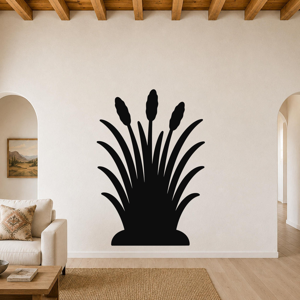 Black metal wall art in a cattail silhouette design, mounted on a living room wall above a beige sofa.