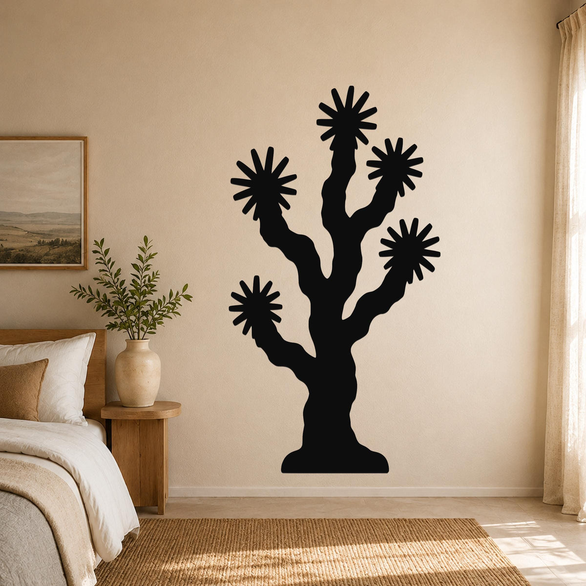 Black metal Joshua tree wall art with starburst cutouts, mounted on a beige bedroom wall above a woven rug.