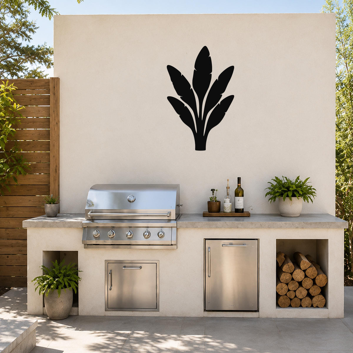 Black metal banana plant wall art with leaf cutouts, mounted on an outdoor patio wall above a kitchen counter.
