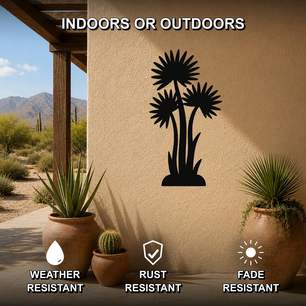 Black metal wall art featuring a silhouette of three desert wildflowers, mounted on an outdoor patio wall with potted plants nearby.