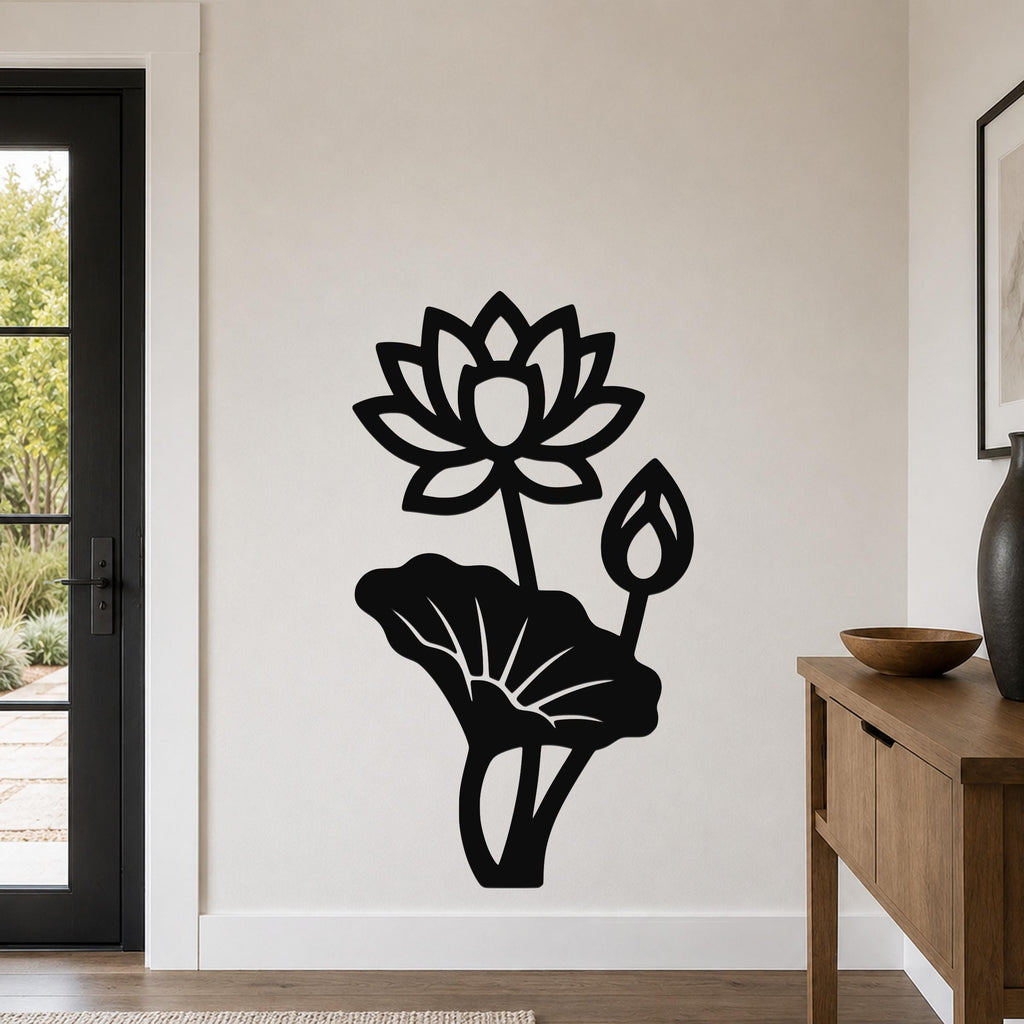 Black metal lotus flower wall art with a large bloom, bud, and leaf cutouts, mounted on a light-colored wall in a modern entryway.
