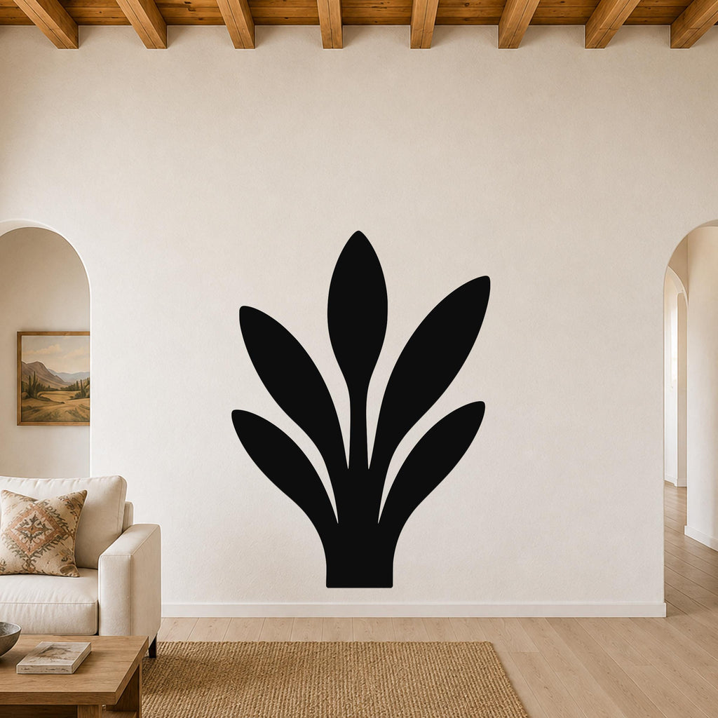 Black metal wall art in a snake plant silhouette, mounted on a living room wall above a sofa.