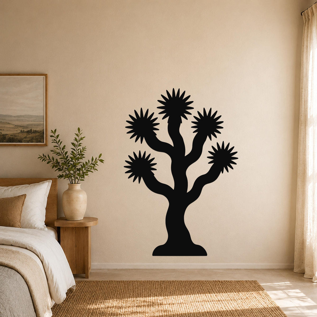 Black metal Joshua tree wall art with starburst-shaped branches, mounted on a beige bedroom wall above a wooden nightstand.