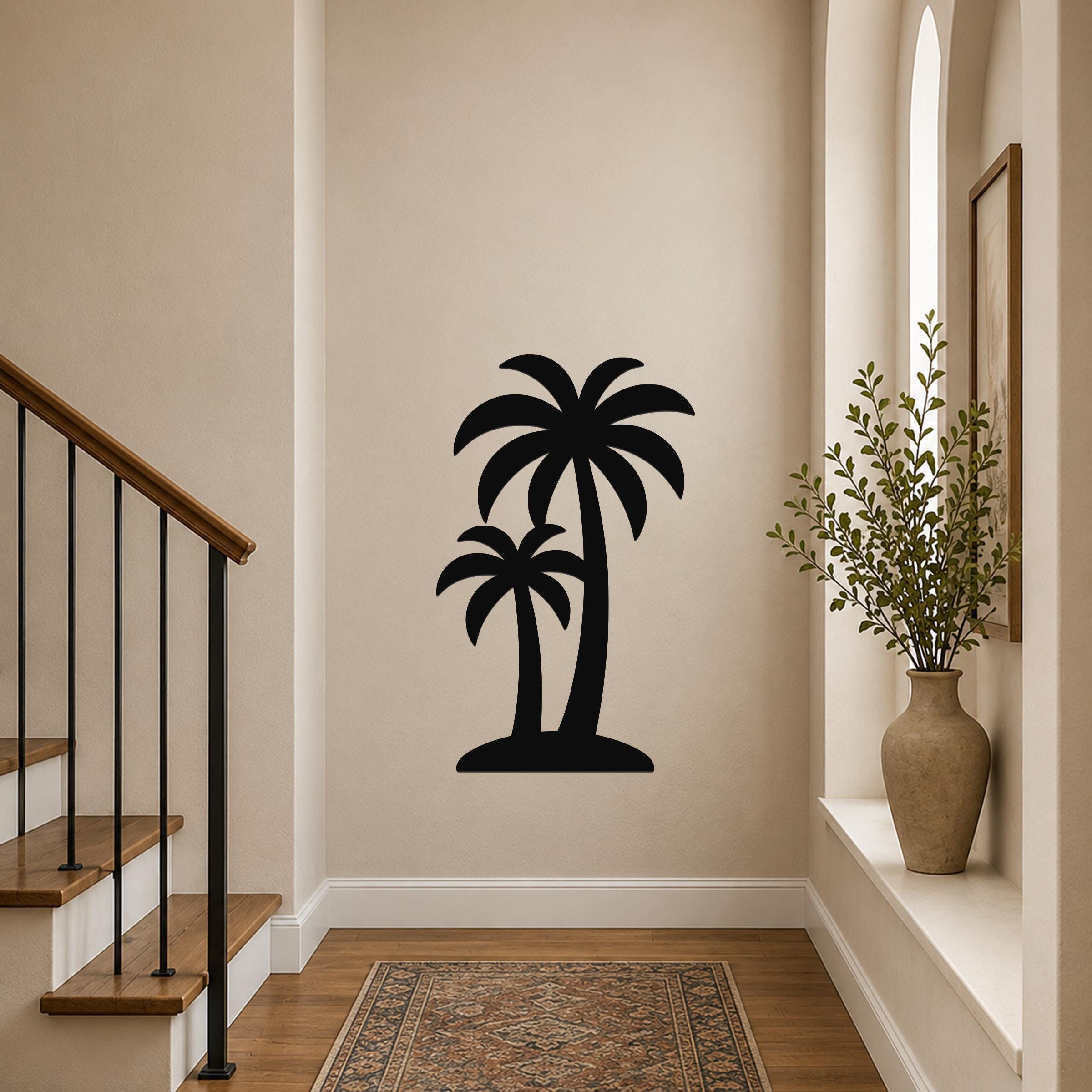 Black metal wall art featuring a silhouette of two palm trees, mounted on a hallway wall above a patterned rug near a staircase.