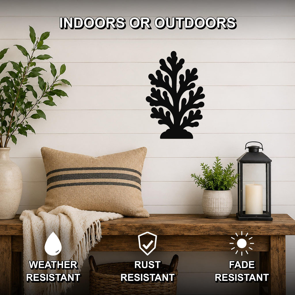 Black metal coral wall art with intricate branch cutouts, mounted on a white shiplap wall above a wooden bench in a living room.