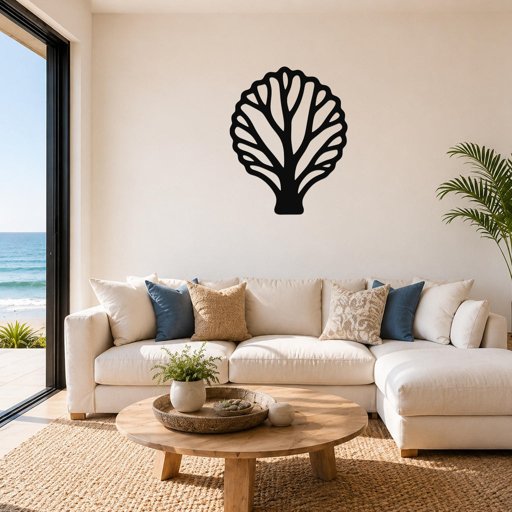 Black metal fan coral wall art with intricate branch cutouts, mounted on a living room wall above a white sofa.