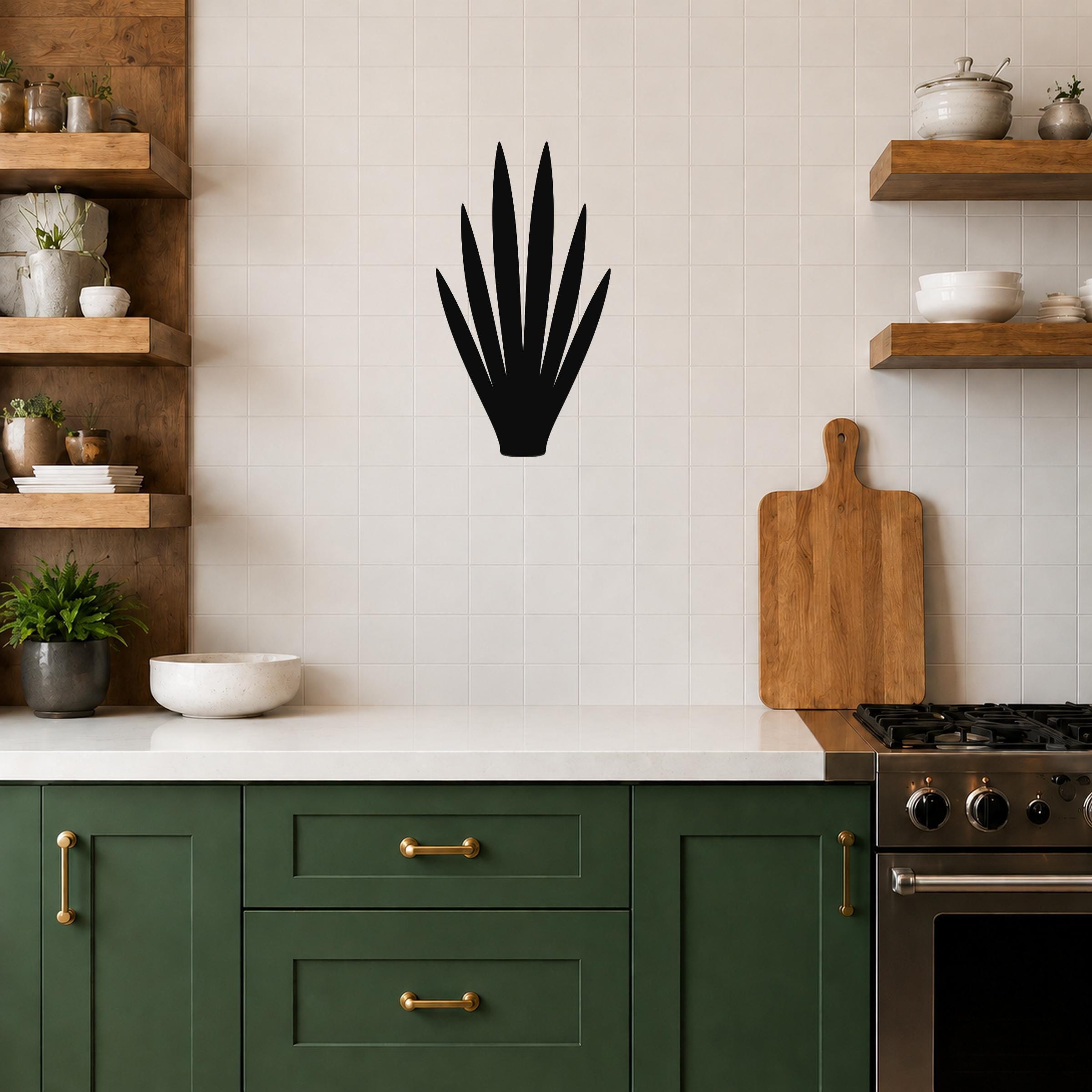 Black metal yucca wall art silhouette with spiky leaves, mounted on a tiled kitchen wall above a counter.