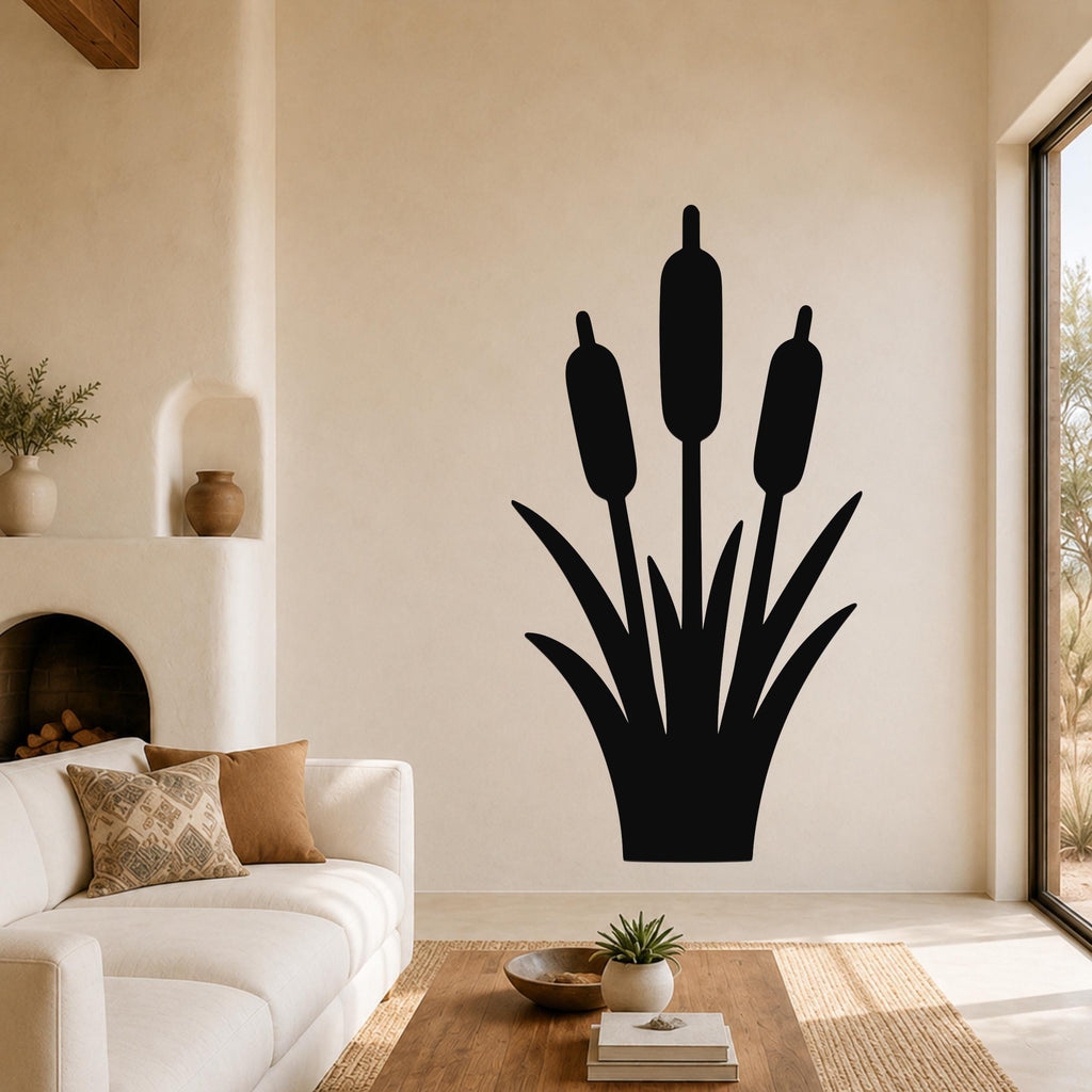 Black metal cattail wall art with three seed heads and leaf cutouts, mounted on a living room wall above a sofa.
