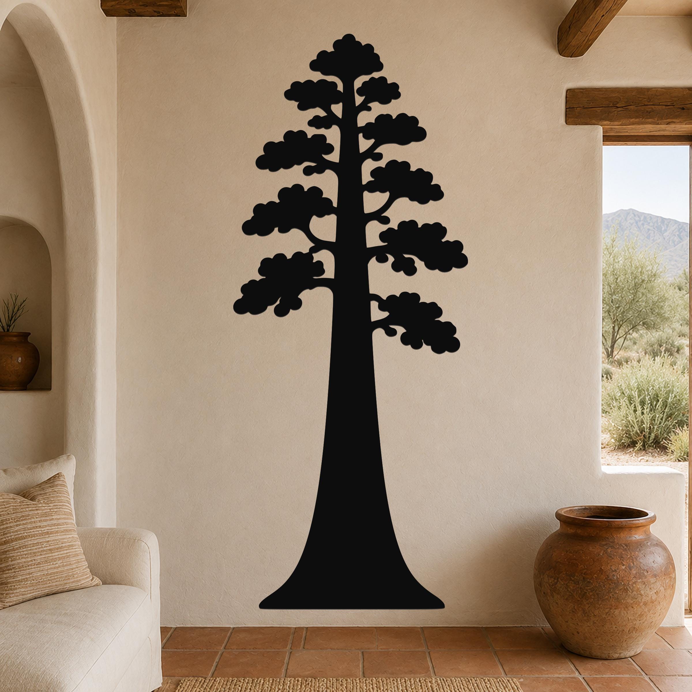 Black metal sequoia tree wall art with layered branch cutouts, mounted on a beige living room wall above a sofa.