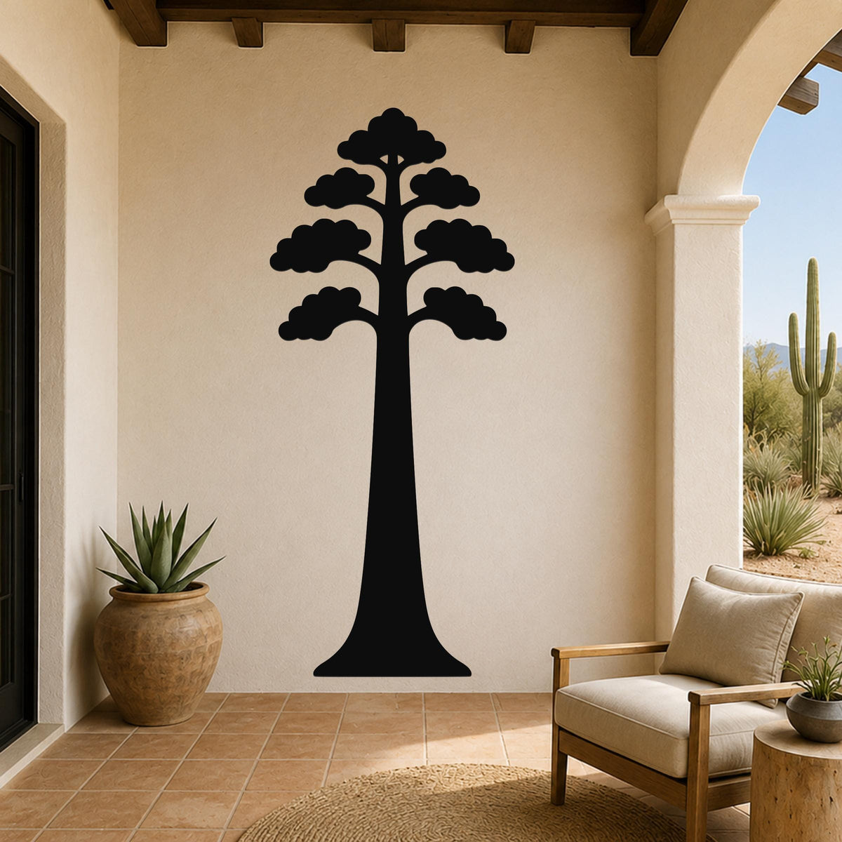Black metal wall art of a sequoia tree silhouette with layered canopy, mounted on a beige stucco wall in a patio living area.