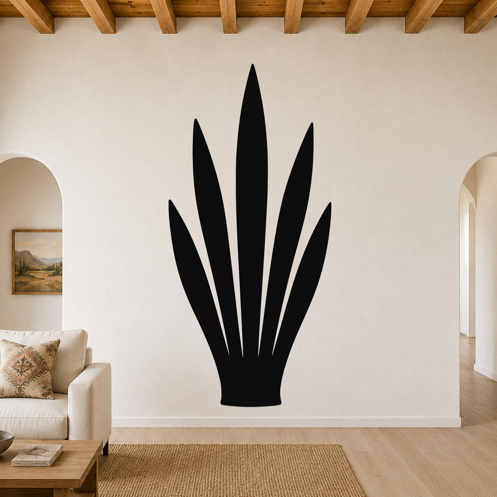 Black metal wall art in the silhouette of a snake plant, mounted on a living room wall above a sofa.
