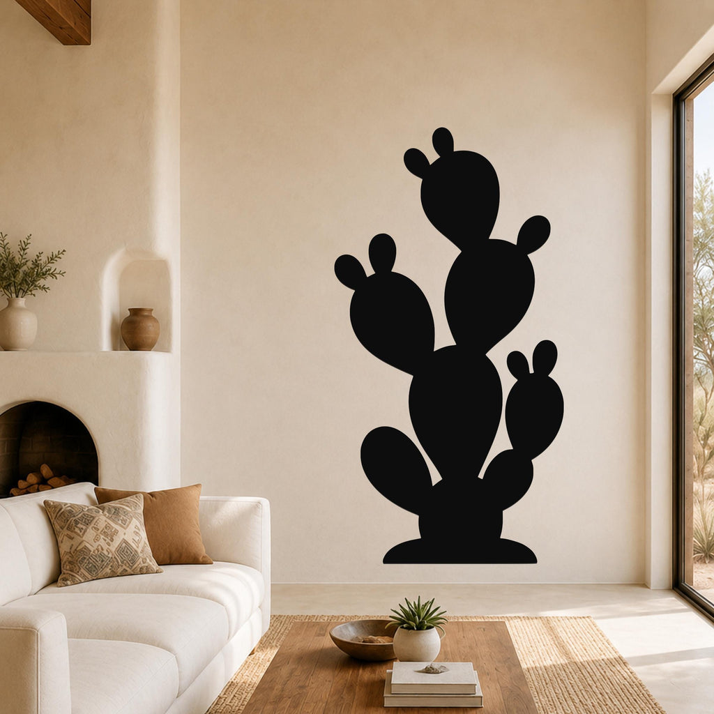 Black metal prickly pear cactus wall art with multiple pads and cutout details, mounted on a living room wall above a sofa.