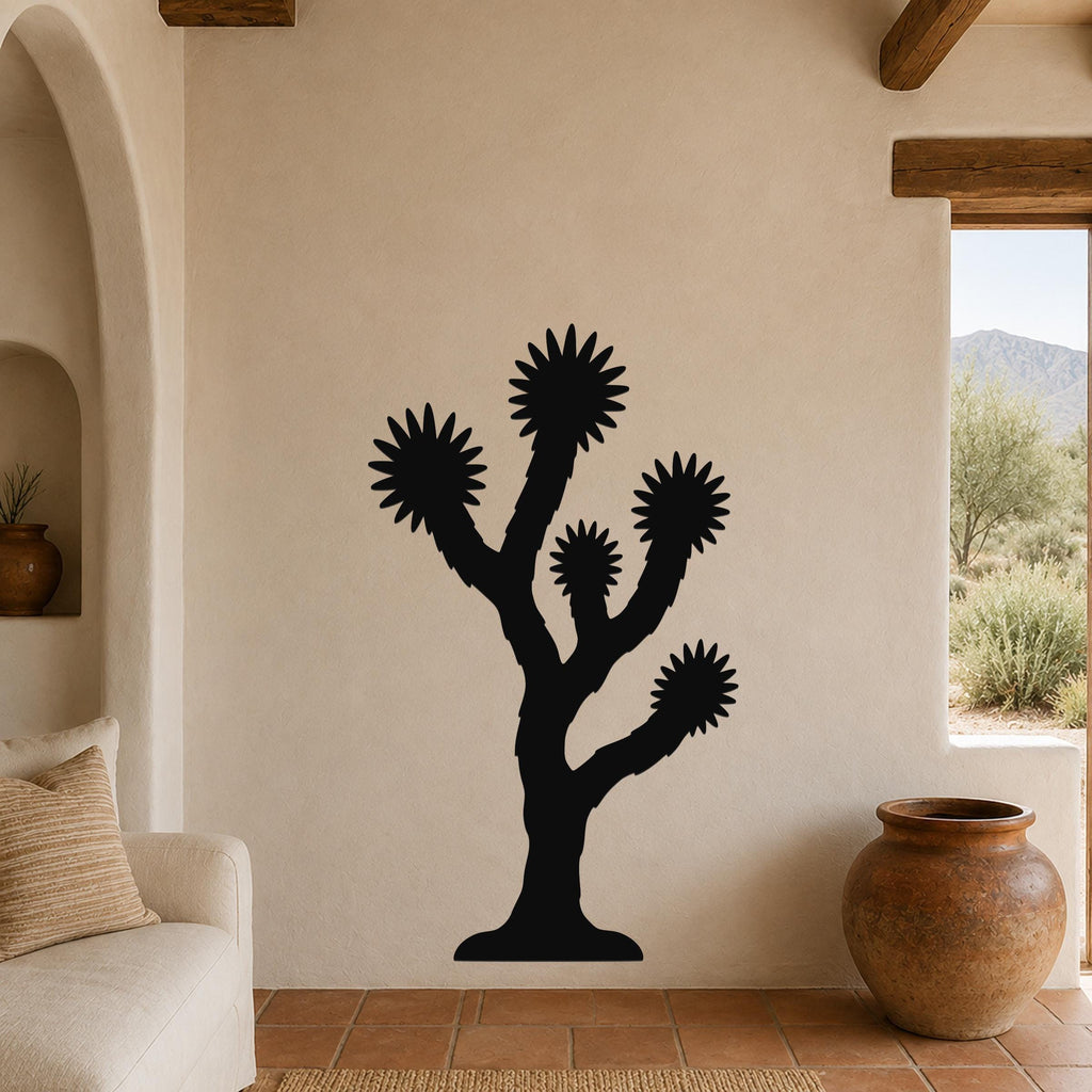Black metal Joshua tree wall art with starburst-shaped branches, mounted on a beige living room wall above a sofa.