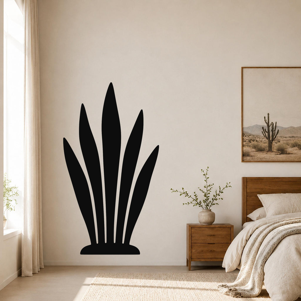 Black metal snake plant wall art with leaf cutouts, mounted on a bedroom wall above a wooden nightstand.