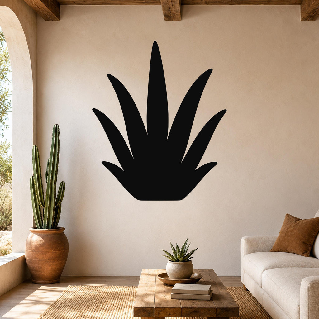 Black metal agave wall art silhouette mounted on a beige living room wall above a wooden coffee table.