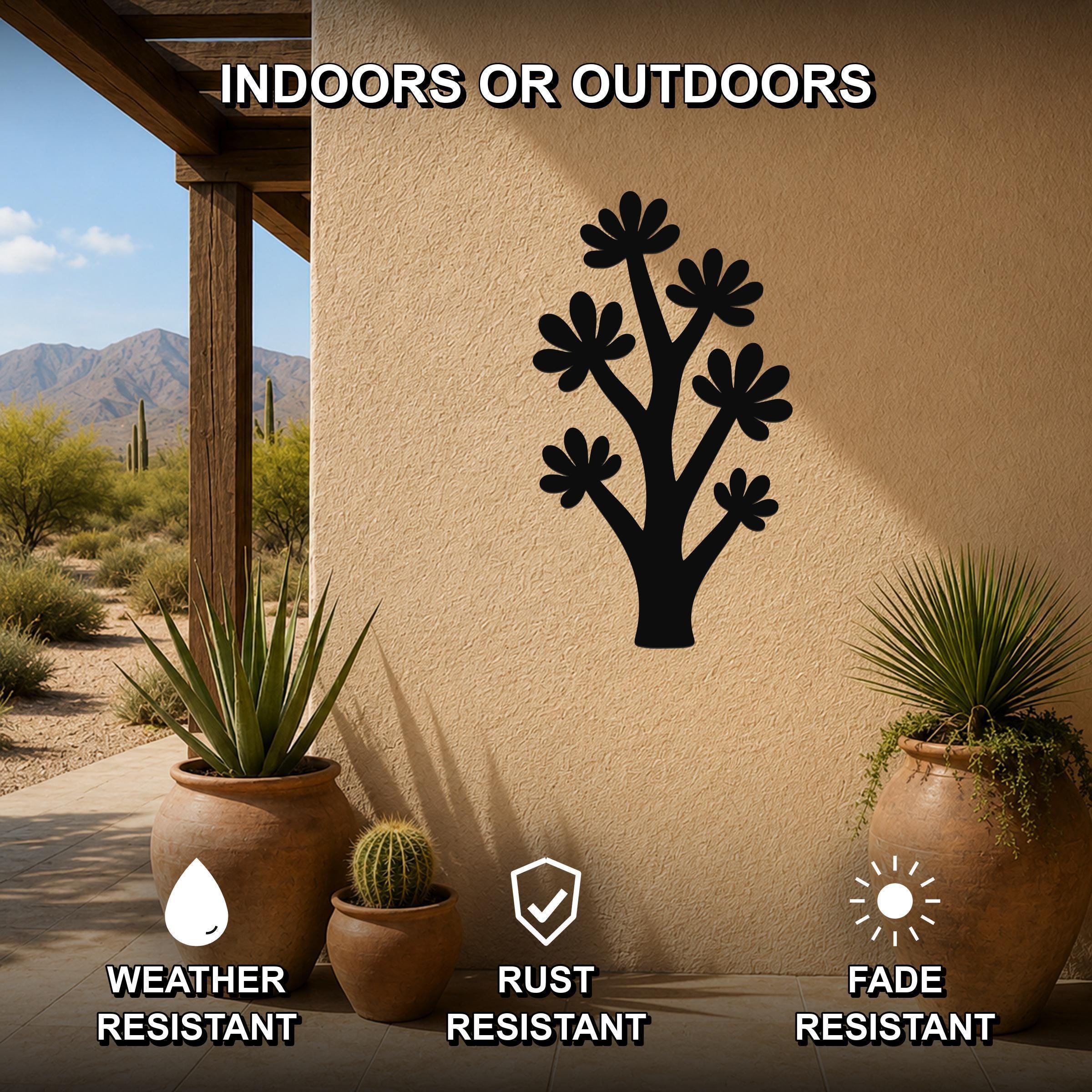 Black metal wall art in a silhouette of a branching wildflower with multiple flower cutouts, mounted on an outdoor patio wall above potted plants.