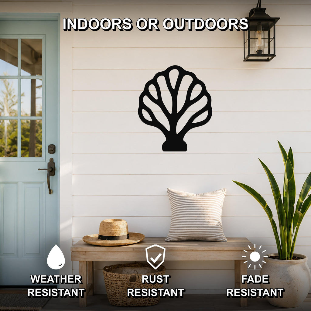 Black metal fan coral wall art with intricate cutout details, mounted on a white shiplap wall above a wooden bench in a covered outdoor entryway.