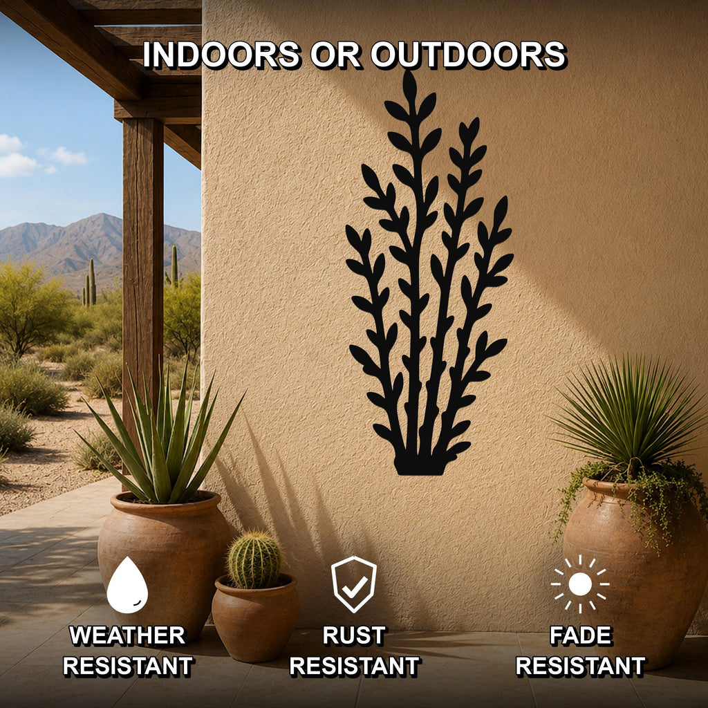 Black metal wall art with a desert branch silhouette, mounted on an outdoor patio wall above potted plants, weather, rust, and fade resistant.