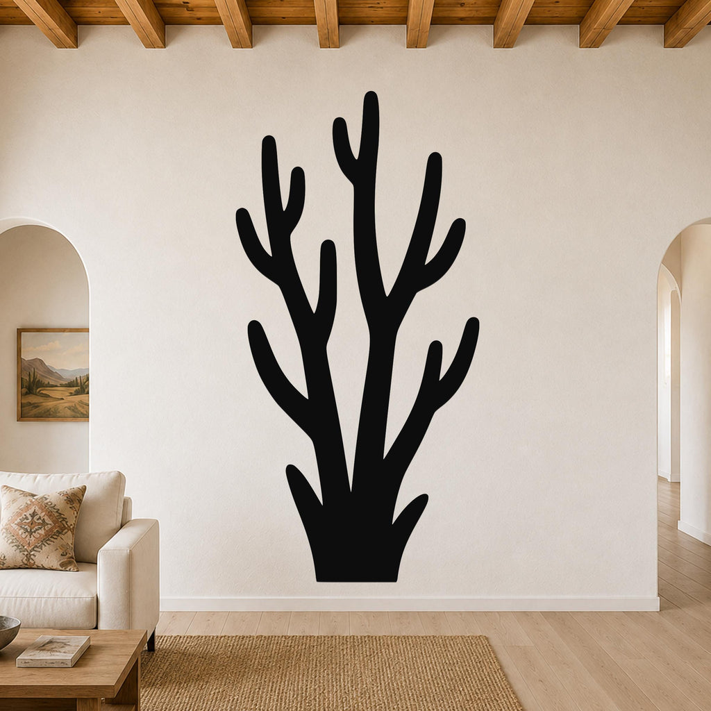 Black metal wall art in a branching cactus silhouette, mounted on a living room wall above a sofa.